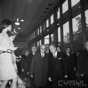 duża grupa ludzi w płaszczach w hali wystawowej