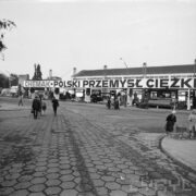 stoisko z maszynami i urządzeniami pod zadaszoną wiatą wystawową, na pierwszym planie betonowy plac, po którym spacerują ludzie