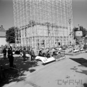 stoisko z rusztowaniami, przed rusztowaniami podnośniki samochodowe, urządzenia, wystawie przyglądają się mężczyźni