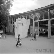 wejście do przeszklonego pawilonu, pośrodku rzeźba w kształcie zaciśniętych dwóch pięści, zwiedzający ludzie