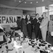 grupa ludzi ogląda stoisko z butami w pawilonie wystawowym