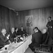 grupa mężczyzn siedzących przy niskim, zastawionym stole