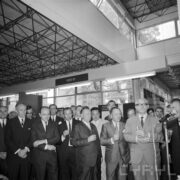 grupa mężczyzn w pawilonie wystawowym, część z nich trzyma w rękach szklanki