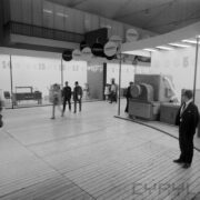 stoiska w hali wystawowej, pomiędzy nimi zwiedzający ludzie