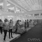 stoiska z ubranymi manekinami w hali wystawowej