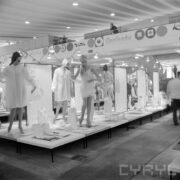 stoiska z ubranymi manekinami w hali wystawowej