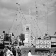 dźwigi budowlane na plenerowej ekspozycji, spacerujący ludzie