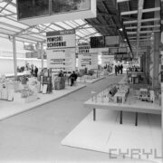 stoiska z urządzeniami pod zadaszoną halą wystawową, pomiędzy stoiskami chodzą ludzie