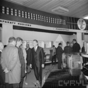 grupy mężczyzn przy stoiskach wystawowych