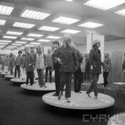 stoiska z ubranymi manekinami w hali wystawowej