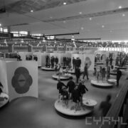 stoiska z manekinami prezentującymi odzież w hali targowej