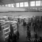 grupy ludzi oglądających stoiska w hali wystawowej