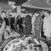 grupa kobiet i mężczyzn ogląda stoisko z butami w pawilonie wystawowym