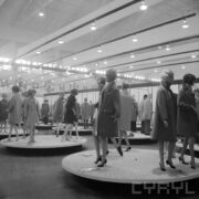 stoiska z ubranymi manekinami w hali wystawowej