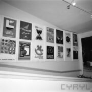 plakaty wiszące w dwóch rzędach na ścianie