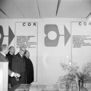 czterech mężczyzn w płaszczach w hali wystawowej