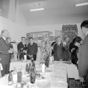 grupa kobiet i mężczyzn stojących przy zastawionym stole