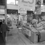 stoiska z maszynami i urządzeniami w hali wystawowej, z lewej dwóch mężczyzn