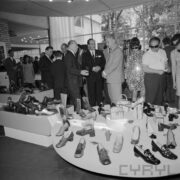 grupa ludzi przy stoisku z butami w pawilonie wystawowym