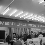 dwie kobiety i grupa mężczyzn w hali wystawowej