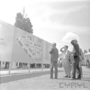 tablica informacyjna, przed nią stoi grupa mężczyzn