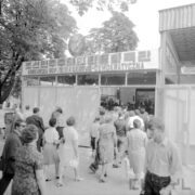 przeszklony budynek, przed nim dużo wchodzących ludzi