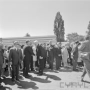 grupa ludzi stoi na terenie targów, część z nich wita się między sobą