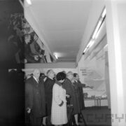 kobiety i mężczyźni, część w płaszczach w hali wystawowej