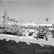 maszyny i urządzenia na betonowym placu, w głębi budynki murowane