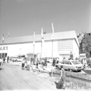 hala wystawowa, przed nią samochody i zwiedzający ludzie