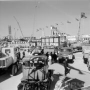 stoiska z samochodami ciężarowymi na placu otoczonym budynkami, zwiedzający ludzie