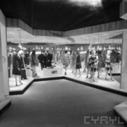 stoiska z ubranymi manekinami w hali wystawowej