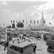 stoiska plenerowe, pomiędzy nimi zwiedzający ludzie