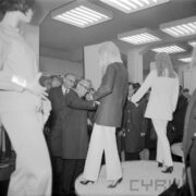 grupa mężczyzn w hali wystawowej ogląda ubrane manekiny