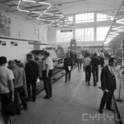 stoiska w pawilonie wystawowym, pomiędzy nimi zwiedzający ludzie