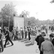 duża grupa ludzi wchodząca przez otwartą bramę