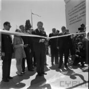 mężczyzna przecina wstęgę, za nim grupa ludzi