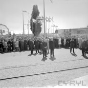duża grupa ludzi na terenie targów, za nimi maszty z flagami państw