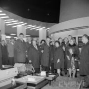 grupa ludzi w płaszczach w hali targowej