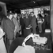 duża grupa ludzi ogląda stoisko w hali wystawowej