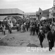 duża grupa ludzi, w większości mężczyzn, zwiedza tereny wystawiennicze