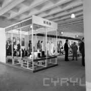 stoiska z odzieżą ochronną prezentowaną na manekinach w hali wystawowej, z prawej trzech mężczyzn