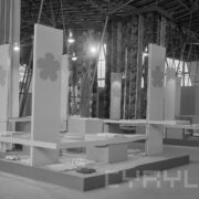 stoisko z wiszącymi z sufitu wzorzystymi tkaninami w pawilonie wystawowym