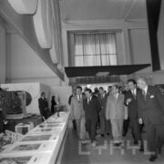 duża grupa mężczyzn ogląda stoiska w hali wystawienniczej