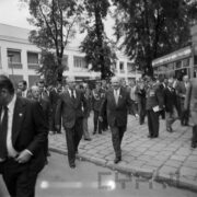 duża grupa mężczyzn na terenie targów, w głębi pawilony wystawowe