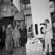 grupa mężczyzn ogląda stoiska w hali wystawienniczej