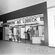 stoisko z manekinami prezentującymi odzież chroniącą przed gazem, z prawej kilka osób