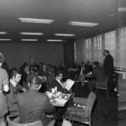 grupy mężczyzn siedzących przy stolikach, na których przygotowano poczęstunek