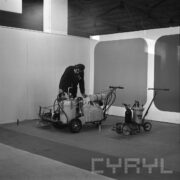 stoisko w hali wystawowej, przy jednym z urządzeń mężczyzna prezentuje jego działanie