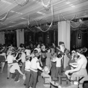 duża sala przyozdobiona serpentynami, na sali dzieci tańczące w kółku